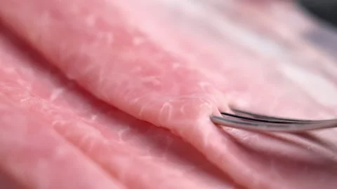 Close up of fork lifting thin slice of cooked ham Stock Footage 333621483