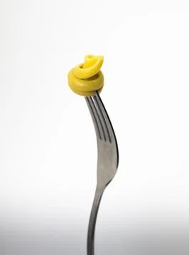Close up of a fork with pasta on a light gray background. Stock Photos