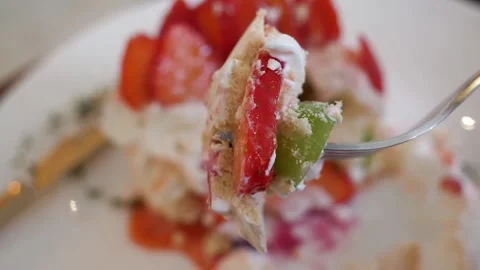 Close-up of Fork Taking a Bite of Fresh Fruit Pavlova with Cream and Berries Stock Footage 331782653