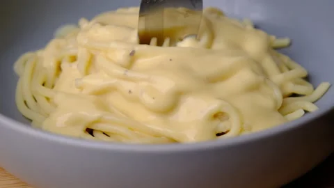 Close up of a fork taking spaghetti with carbonara sauce from a plate. Stock Footage 179295844