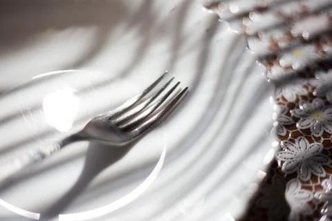 Close-up of fork in white plate on table. Stock Photos