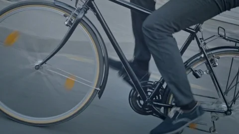 Close-up of formally dressed commuter pedaling on the street Stock Footage 74636337