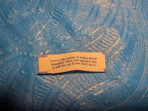 Close-up of fortune cookie message reading “Love is like paint Stock Photos