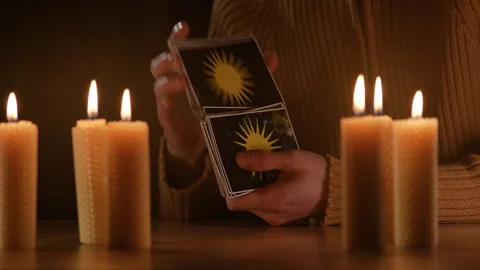 Close Up Fortune Teller Hands Shuffling Tarot Cards By Candlelight Video stock 329305866