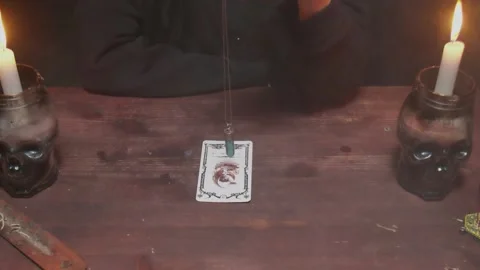 Close up of fortune teller tarot reader uses a blue magic crystal and tarot Stock Footage 145778745