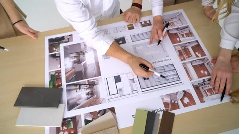Close Up Of four Architects Discussing Plan Together At Desk With Blueprints Stock Footage 88612988