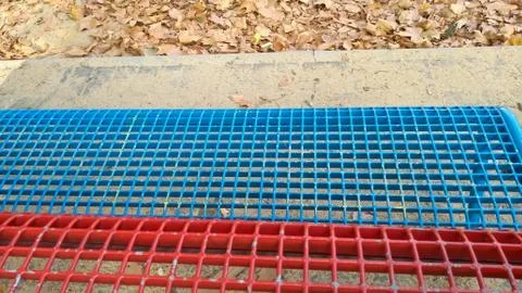 Close up four different textures: sand, concrete, red and blue metallic grill. Stock Photos