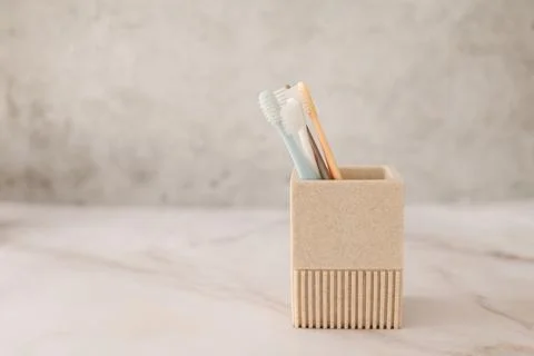 A close-up of four toothbrushes in a cup. Stock Photos