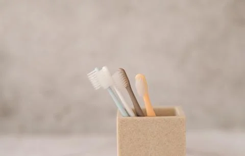 A close-up of four toothbrushes in a cup. Stock Photos