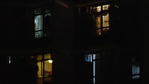 Close up of Four windows of apartments with lights on during nighttime Stock Footage 295921927