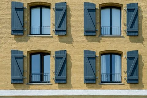 Close up of four windows with Z shaped shutters on yellow facade in Copenha.. Stock Photos
