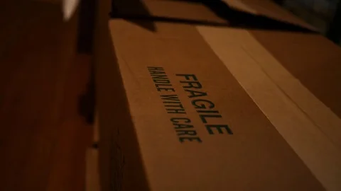 Close up of fragile cardboard box being picked up by postal worker Stock Footage 83522975