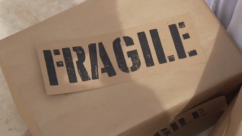 Close up of fragile cardboard box being picked up by postal worker Stock Footage 106113175
