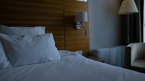 Close-up fragment of bedroom with empty bedside table, reading lamp  Stock Footage 244773476