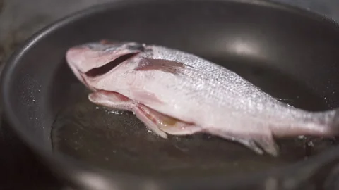 Close-up of fragrant and fresh fish fried in a pan under the control of the chef 스톡 동영상 150418804