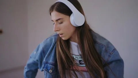 Close up frame of dancing girl in a white headphones and blue jacket Vídeos de archivo 150399299