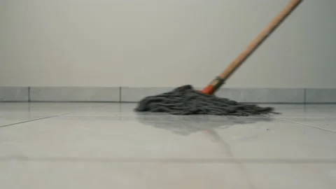Close-up frame of a mop moving on the floor on a tile. Cleaning and cleanliness Stock Footage 151349155