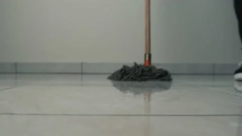 Close-up frame of a mop moving on the floor on a tile. Cleaning and cleanliness Stock Footage 151349196