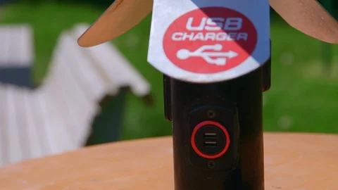 Close-up frame moving from bottom to top of a USB street charger in the park 库存影片 129524042