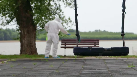 Close frame on the swing. Man wearing protective suit disinfecting the bank w 스톡 동영상 130976641