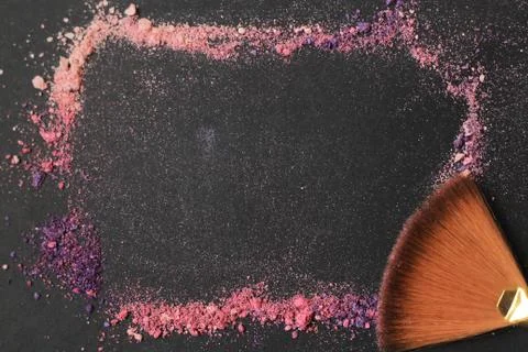 Close up. frame for text with brushes for make-up and grains of dust on a black Stock Photos