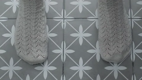 Close-up frame of women's night in a warm sock on between which a few drops of Stock Footage 147840001
