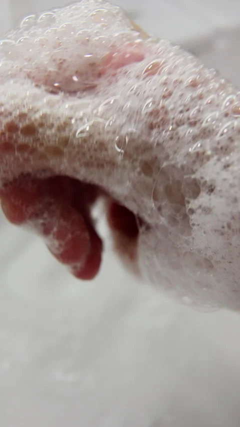 Close-up frames show hands being carefully washed with soap and water, dense Stock Footage 317546369