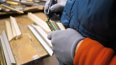 Close-up. Framing Workshop. A man makes a frame for a picture made of beads Stock Footage 128739307