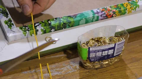 Close-up. Framing Workshop. A man makes a frame for diamond mosaic Stock Footage 128739573