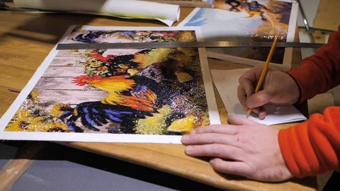 Close-up. Framing Workshop. A man makes a frame for a picture made of beads Stock Footage 128762364