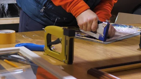 Close-up. Framing Workshop. A man makes a frame for a picture made of beads Stock Footage 128763510