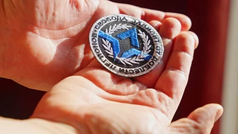 Close-up of the Freedom of Russia Legion patch resting on hands, revealing Stock Footage 304590006