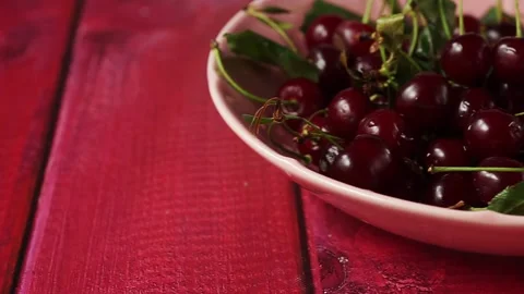 Close up of frehs and juicy red cherry berries on red wooden table Stock Footage 135699267