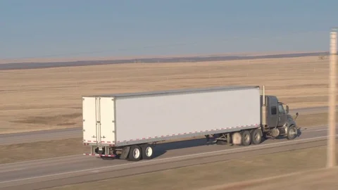 CLOSE UP: Freight container semi truck driving along the empty rural highway Video stock 76803412