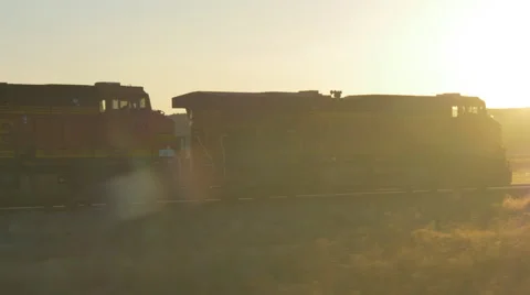 CLOSE UP: Freight container train moving along railroad tracks at golden sunset Stock Footage 62331825