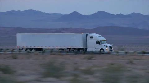CLOSE UP: Freight semi truck driving and transporting goods on empty highway Stock Footage