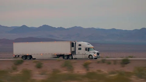 CLOSE UP: Freight semi truck driving and transporting goods on empty highway Stock Footage 78992044