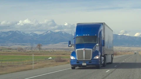 CLOSE UP: Freight semi truck hauling goods along the country road on sunny day Stock Footage
