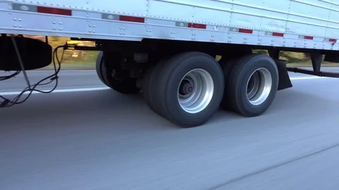CLOSE UP: Freight semi truck passing by on highway, tires and wheels rolling Stock Footage