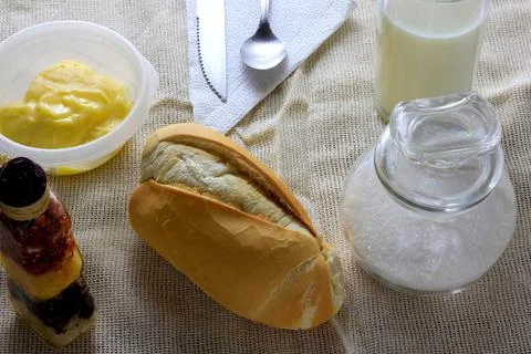 Close up french bread on breakfast table with butter and cutlery Stock Photos