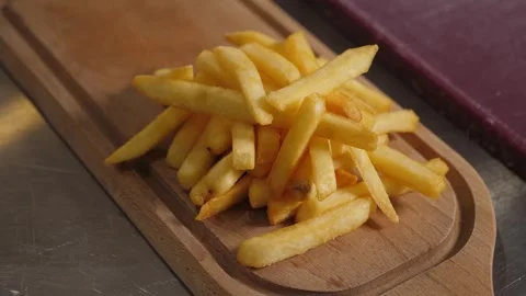 Close-up of French fries on a wooden rectangular plate in the kitchen. Stock Footage 342702607