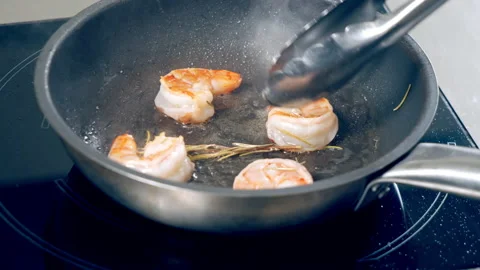 Close-up of fresh appetizing shrimps fried with rosemary in oil in a frying pan Stock Footage 147738462