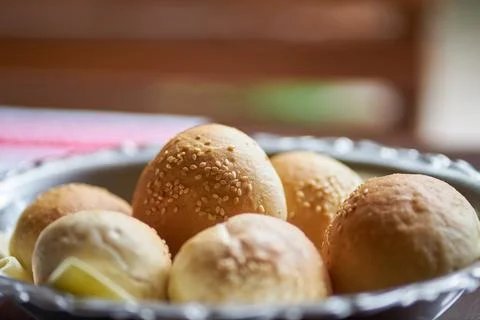 Close up of fresh baked bread rolls with sesame seeds in a metal bowl Stock Photos