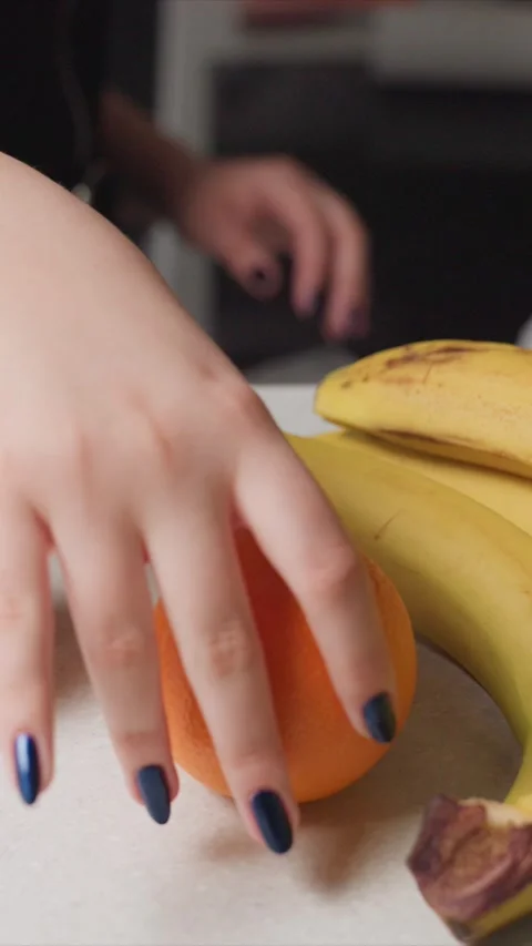 Close up of fresh bananas orange apple being carefully arranged on white surface Stock Footage 346794958