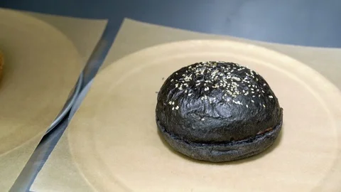 Close - up of fresh burger bun served on pieces of brown paper Stock Footage 115840702