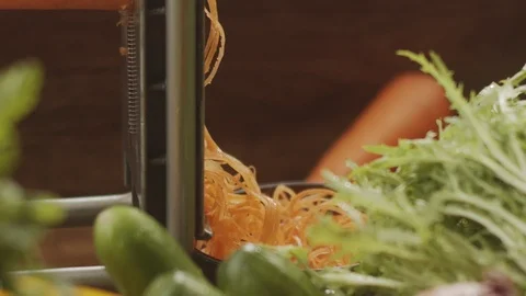 Close-up of fresh carrots grated on the kitchen table in slow motion Stock Footage 124729330
