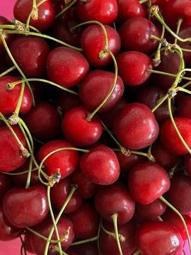 A close-up of fresh cherries with stems, piled together Stock Photos