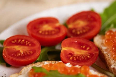 Close-up of fresh cherry tomatoes with red caviar sandwiches Stock Photos