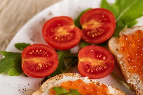 Close-up of fresh cherry tomatoes with red caviar sandwiches Stock Photos