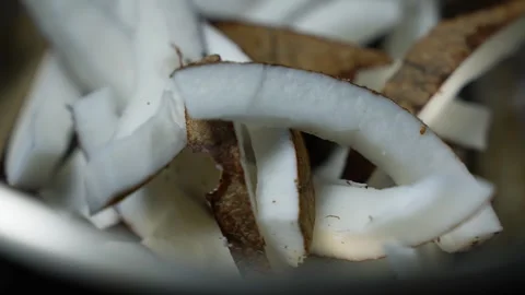 Close up of fresh coconut slices with white flesh and brown skin, showing a.. Stock Footage 339022616